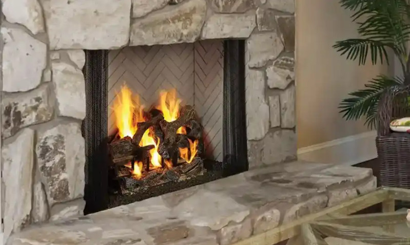 Modern outdoor patio with built-in gas fireplace and cozy seating area at sunset